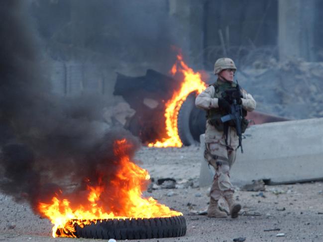 A US soldier walks through debris left by a massive car bomb that exploded near the Australian Embassy in 2005 in the al Karrada neighbourhood of Baghdad, Iraq. Picture: Darren McCollester