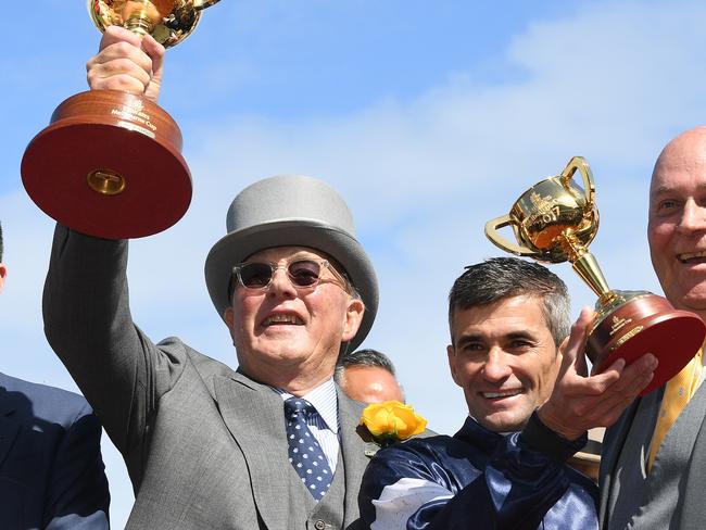 (L-R) Trainer Joseph O'Brien, part owner Lloyd Williams, jockey Corey Brown are seen holding the respective Melbourne Cup trophies after Rekindling won the Melbourne Cup at Flemington Racecourse in Melbourne, Tuesday, November 7, 2017. (AAP Image/Julian Smith) NO ARCHIVING