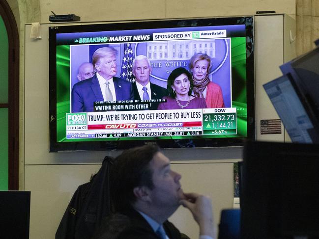 A trader at the New York Stock Exchange listen to President Donald Trump's televised White House news conference. Picture: AP