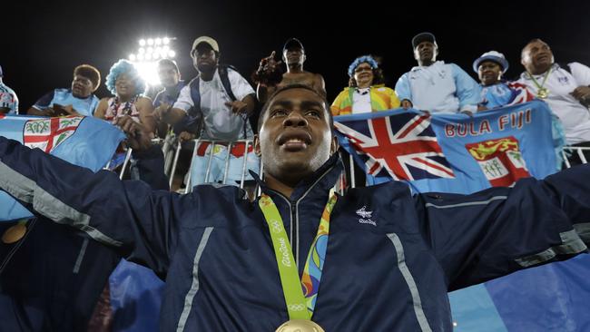Viliame Mata of Fiji poses with fans after winning the gold medal match against Britain.