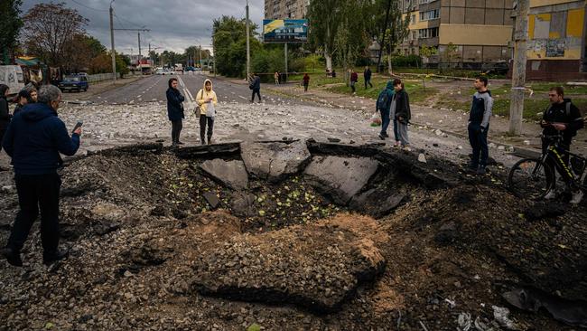 Local residents examine a crater following a missile strike in Dnipro. Picture: AFP