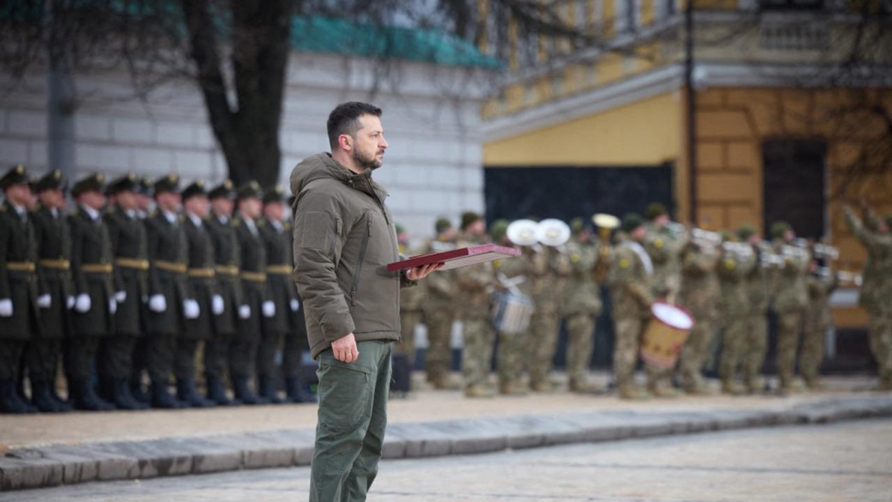 Volodymyr Zelenskyy standing and holding an award during a ceremony at St Sophia Square in Kyiv, on the first anniversary of the Russian invasion. Picture: AFP