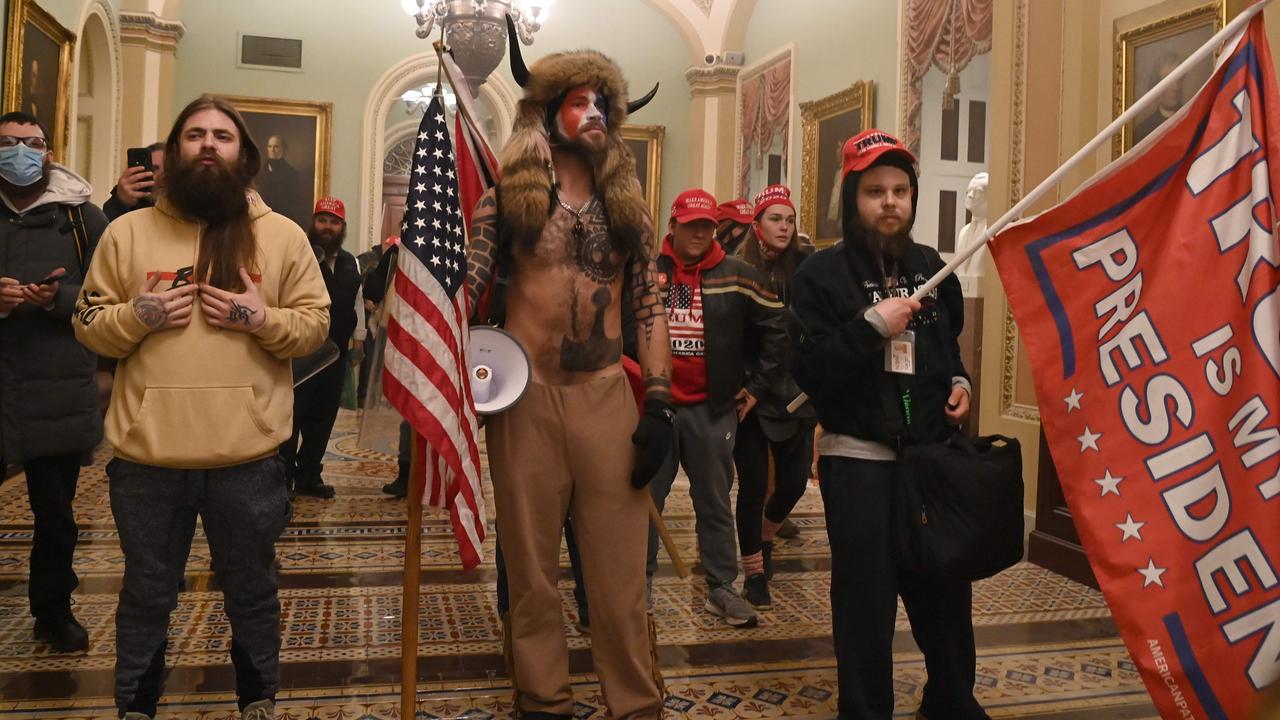 Horned protester Jake Angeli (centre) is in prison on federal charges and refusing a COVID-19 vaccine. Picture: Saul Loeb/AFP