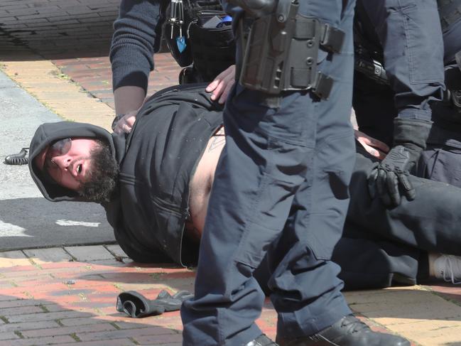 Police restrain a man, believed to be a relative of Preston, after he crossed the police tape. Picture: David Crosling