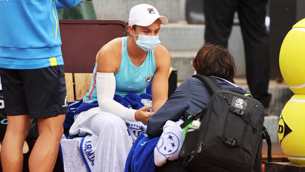 Ash Barty chats to the trainer before retiring hurt while playing Coco Gauff. (Photo by Clive Brunskill/Getty Images)