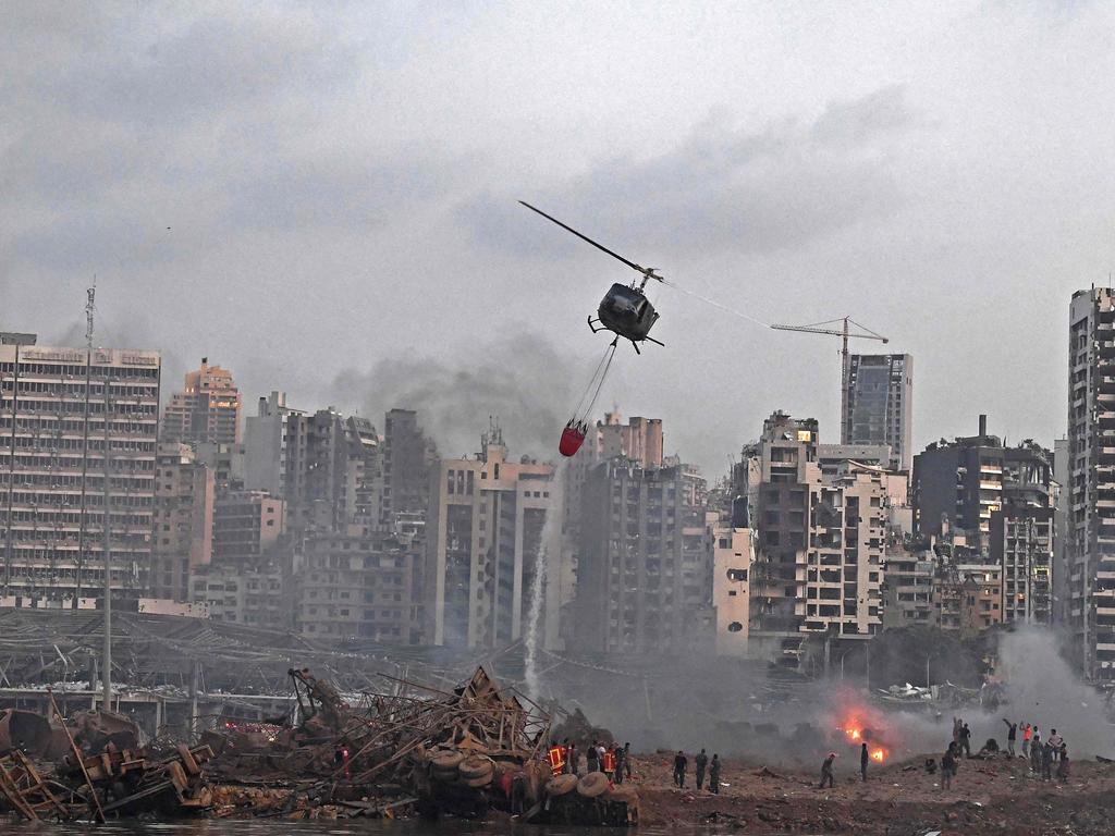 A helicopter try to put out multiple fires at the scene. Picture: AFP