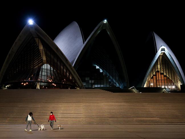 SYDNEY, AUSTRALIA - JUNE 26: People walk dogs at an empty Sydney Opera House which is closed due to Covid-19 on June 26, 2021 in Sydney, Australia. Lockdown restrictions have come into effect across Great Sydney, the Blue Mountains, the Central Coast and Wollongong as NSW health authorities work to contain a growing COVID-19 cluster. From 6pm on Saturday, all residents in areas subject to stay-at-home orders are only permitted to leave their homes for essential reasons, including purchasing essential goods, accessing or providing care/healthcare, work, education and exercise. The restrictions will remain in place until midnight on Friday 9 July. (Photo by Brendon Thorne/Getty Images) *** BESTPIX ***