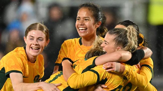 Australia's defender Charlotte Grant (2R) is mobbed by teammates after scoring the team's second goal during the International football friendly match between England and Australia at the Gtech Community Stadium in Brentford, west London on April 11, 2023. (Photo by Glyn KIRK / AFP)