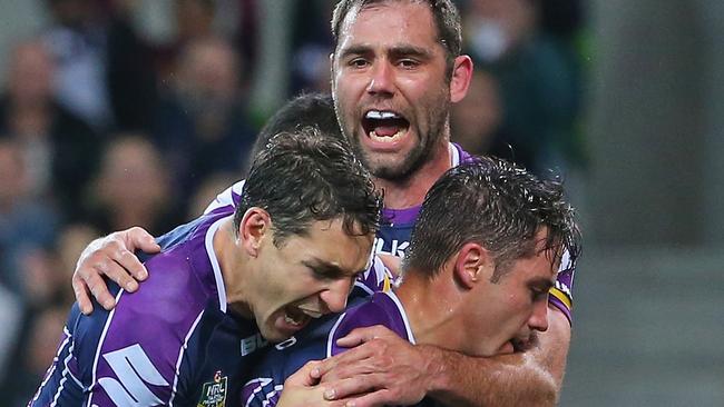 MELBOURNE, AUSTRALIA - SEPTEMBER 05: Cooper Cronk of the Storm is congratulated by Cameron Smith and Billy Slater after scoring a try during the round 26 NRL match between the Melbourne Storm and the Brisbane Broncos at AAMI Park on September 5, 2014 in Melbourne, Australia. (Photo by Scott Barbour/Getty Images)