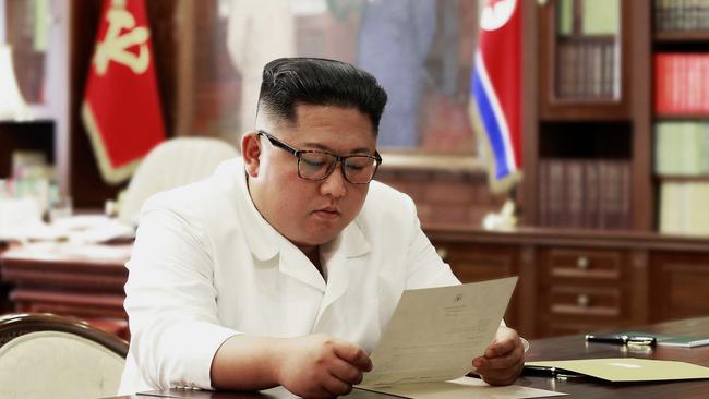 North Korean leader Kim Jong-un reads a letter from US President Donald Trump. Picture: AP