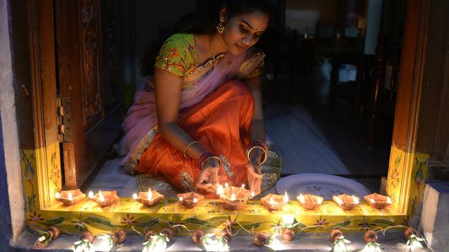 An Indian woman Nikitha places earthen lamps or 'diyas' at the entrance of her home on the eve of Diwali Festival in Hyderabad. Picture: AFP