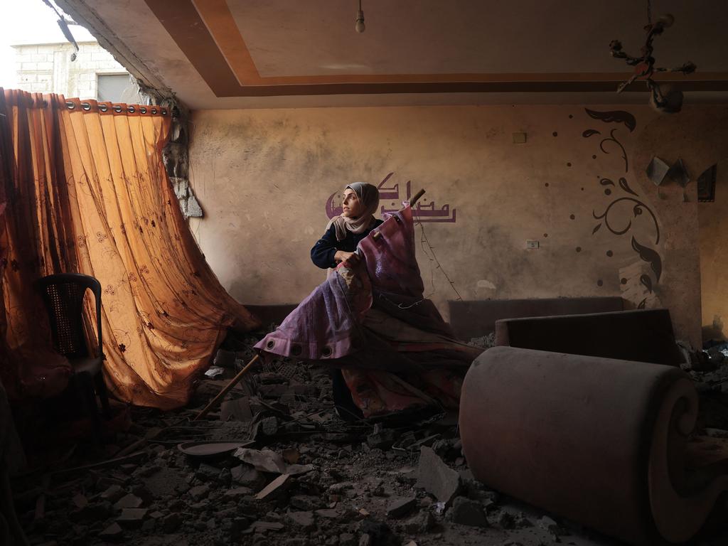 After Israeli bombardment, a relative salvages items from the home of the Sheikh el-Eed family, where the mother and two children lost their lives. Picture: Said Khatib/AFP