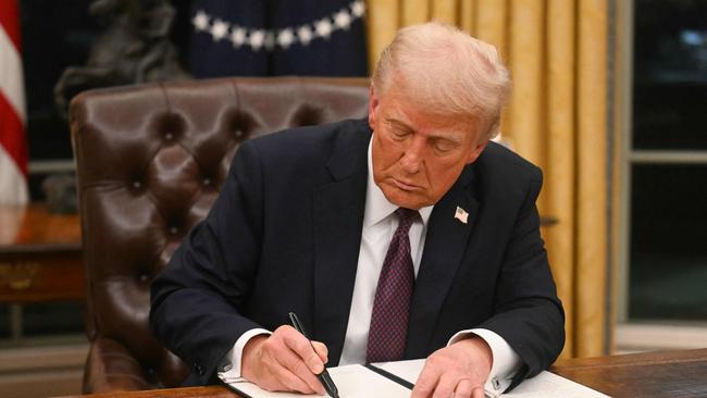 US President Donald Trump signs an executive order in the White House’s Oval Office. Picture: Jim Watson/AFP