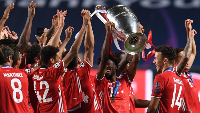Goalscorer Kingsley Coman raises the trophy as Bayern Munich players celebrate