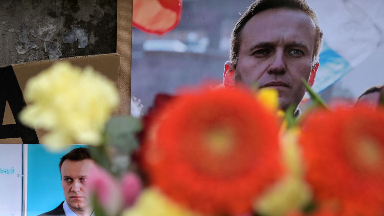 Flowers are seen placed around portraits of late Russian opposition leader Alexei Navalny at a makeshift memorial in front of the former Russian consulate in Frankfurt, Germany. (Photo by AFP)