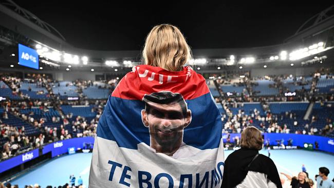 A supporter of Serbia's Novak Djokovic stands with a flag.