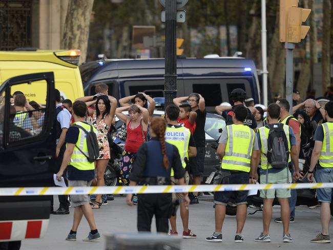 Policemen check the identity of people standing with their hands up after a van ploughed into the crowd. Picture: AFP