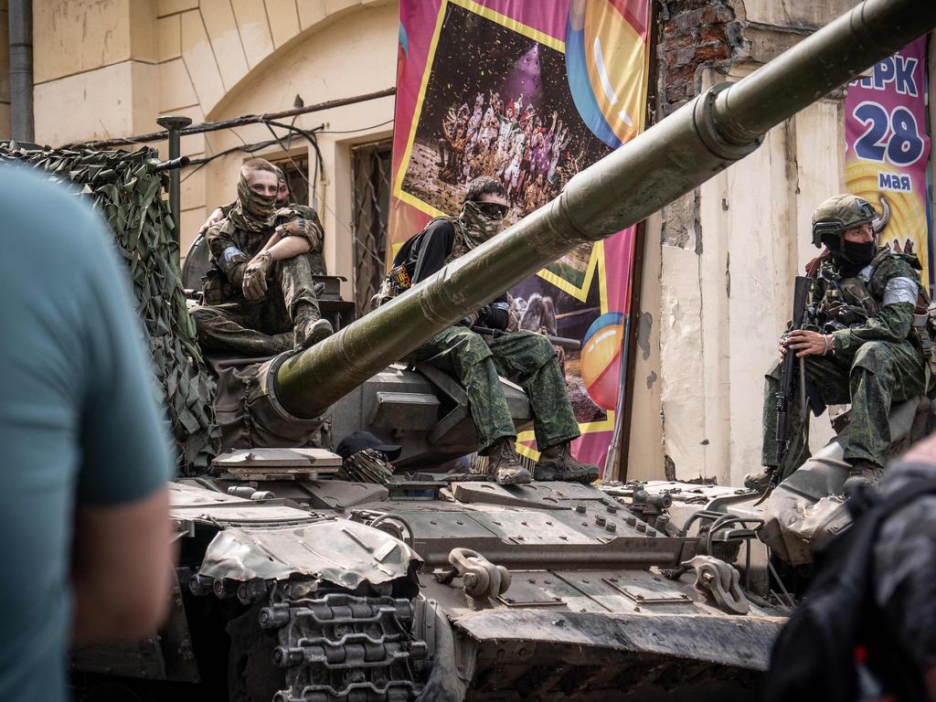 Members of Wagner group sit atop of a tank in a street in the city of Rostov-on-Don.