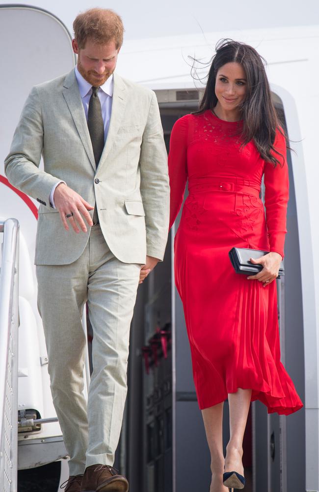 She’s red-y! Prince Harry and Meghan Markle, in a Self-Portrait dress, at Fua'amotu Airport in Tonga. Picture: Getty Images