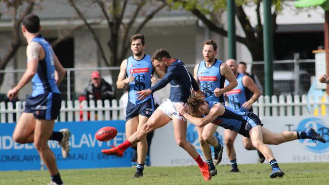 Redlegs midfielder Matthew Nunn kicks his side deep in attack under pressure from the Double Blues. Picture: Russell Millard/AAP