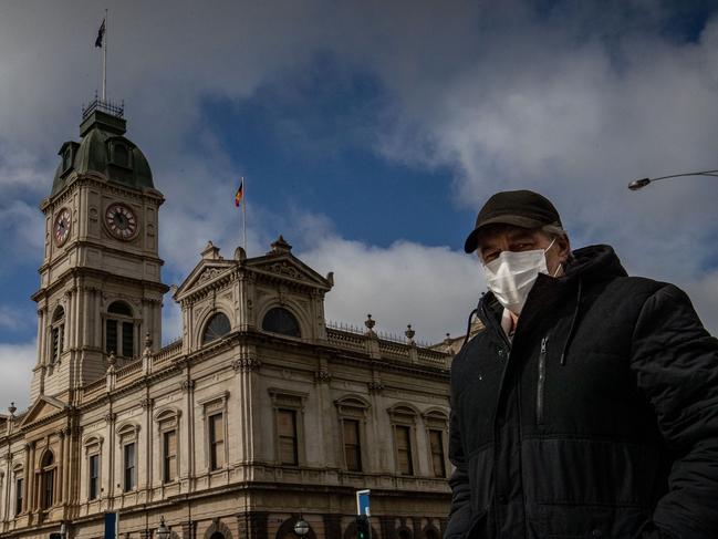 BALLARAT, AUSTRALIA - AUGUST 21: A man wearing a mask walks across Sturt Street in Ballarat on August 21, 2020 in Ballarat, Australia. COVID-19 testing in Ballarat has increased as health authorities work to avoid the spread of coronavirus in regional Victoria. Metropolitan Melbourne is under stage 4 lockdown restrictions, with people only allowed to leave home to give or receive care, shopping for food and essential items, daily exercise and work while an overnight curfew from 8pm to 5am is also in place. The majority of retail businesses are also closed. Other Victorian regions are in stage 3 lockdown. The restrictions, which came into effect from 2 August, have been introduced by the Victorian government as health authorities work to reduce community COVID-19 transmissions across the state. (Photo by Darrian Traynor/Getty Images)