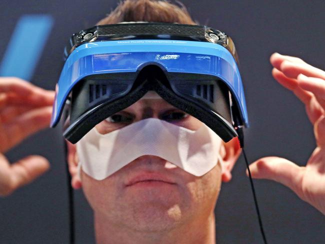 Microsoft employee Dave Rogers pulls off a HoloLens device after trying it out in a Windows mixed reality immersive experience at the Microsoft Build 2017 developers conference, Wednesday, May 10, 2017, in Seattle. Earlier in the day at the annual event, Microsoft CEO Satya Nadella said that a half billion devices are now running Windows 10, its latest operating system. That's up from 400 million disclosed last September, but far short of a goal of 1 billion by 2018. (AP Photo/Elaine Thompson)