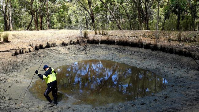 An investigator checks a drained dam in Toolern Vale during the search for missing mum Karen Ristevski. Picture: Nicole Garmston