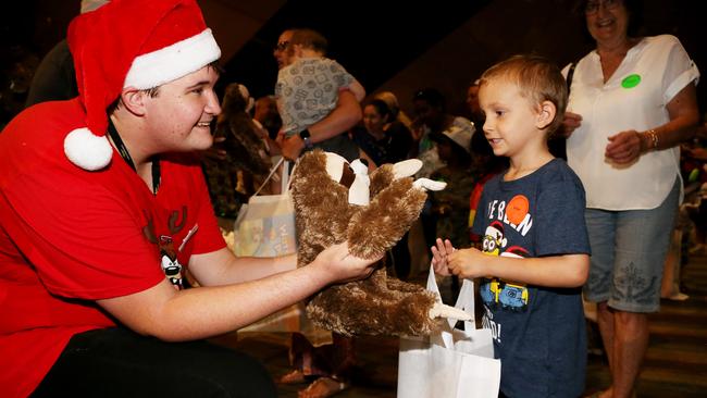 Volunteer Michael Kitto gives Chace Lock, 6, of Woree a sloth teddy in the Toy Shop at the annual Special Children's Christmas Party held at the Cairns Convention Centre. PICTURE: STEWART MCLEAN