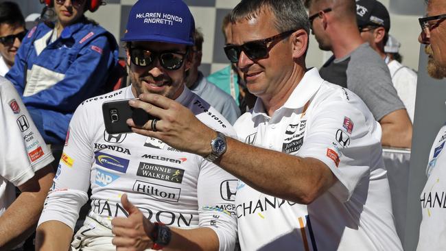 Fernando Alonso, left, of Spain, takes a photo with a member of his crew.