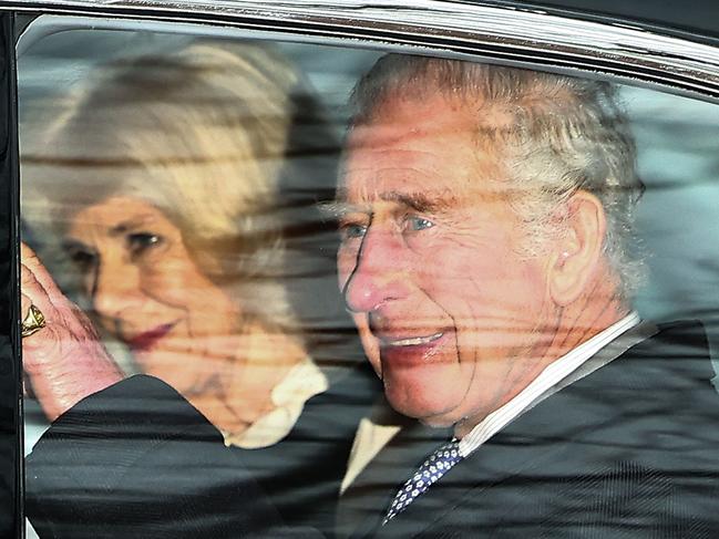 Britain's King Charles III and Britain's Queen Camilla wave as they leave by car from Clarence House in London on February 6, 2024. King Charles III's estranged son Prince Harry reportedly arrived in London on Tuesday after his father's diagnosis of cancer, which doctors "caught early". (Photo by HENRY NICHOLLS / AFP)