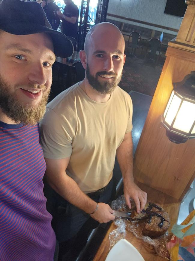 Joel Davis, left, and Thomas Sewell cut a swastika cake on April 20 at a birthday party for Adolf Hitler at a gathering in Victoria.