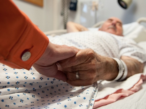 This senior citizen gets comfort from his daughter as she holds his hand before surgery (that will later reveal cancer).RendezView