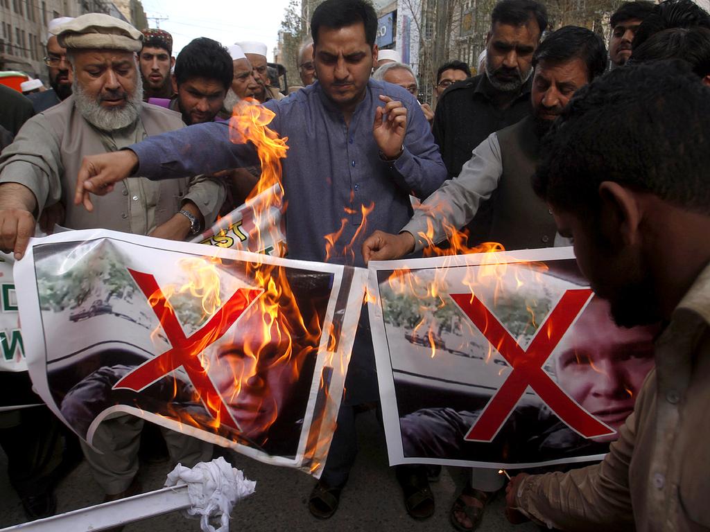 Pakistani traders burn pictures of Brenton Tarrant in Peshawar. Picture: AP 