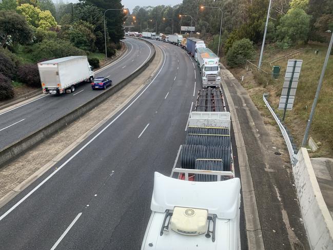 Trucks are lined up for Kilometres and cars diverted to Greenhill Road as Police and Emergency workers remove an overturned chicken truck on the South Eastern Freeway, heading into the city just below the Crafers ramp. (AAP Image/Emma Brasier)