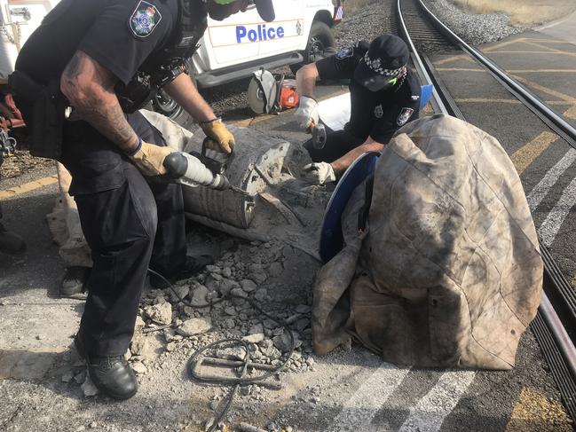 Queensland police officers remove a drum barricade at the Abbot Point coal terminal.