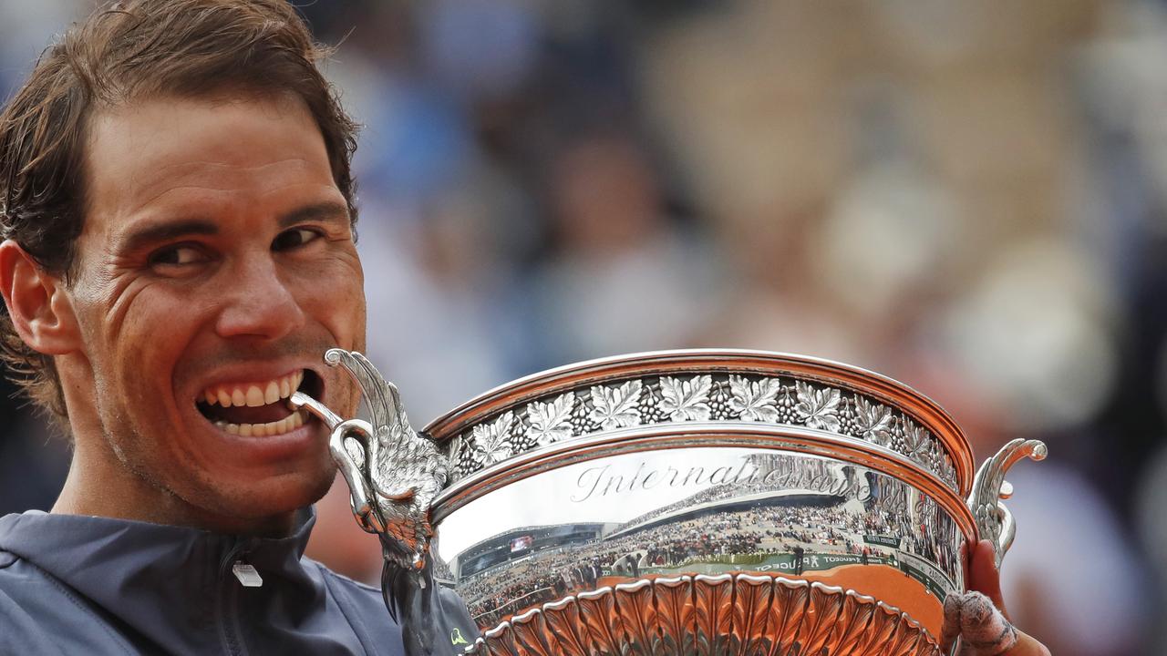 Spain's Rafael Nadal Bites The Trophy As He Celebrates Winning The Men