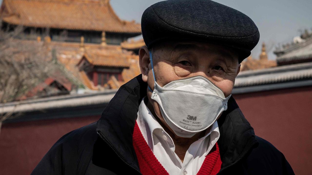 A man wearing a protective facemask walks on a street outside the Lama Temple in Beijing that is closed due to coronavirus epidemic.