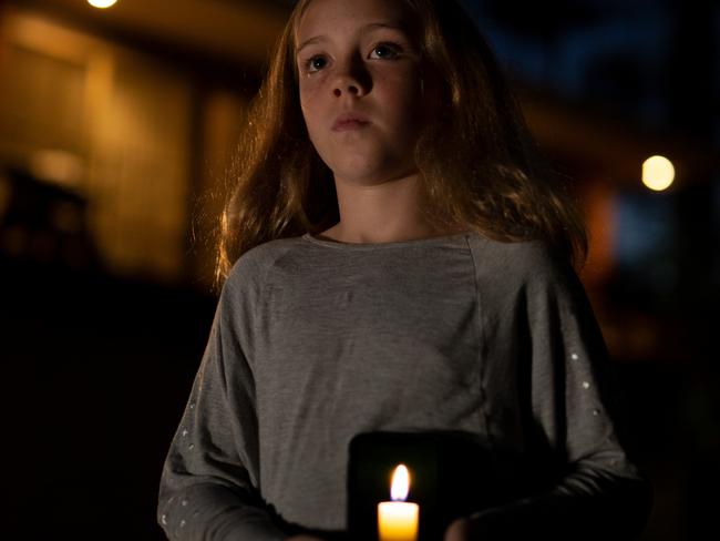 A girl using the Virtual Candle in the News Corp app for Anzac Day 2020. Credit: Grainger Films