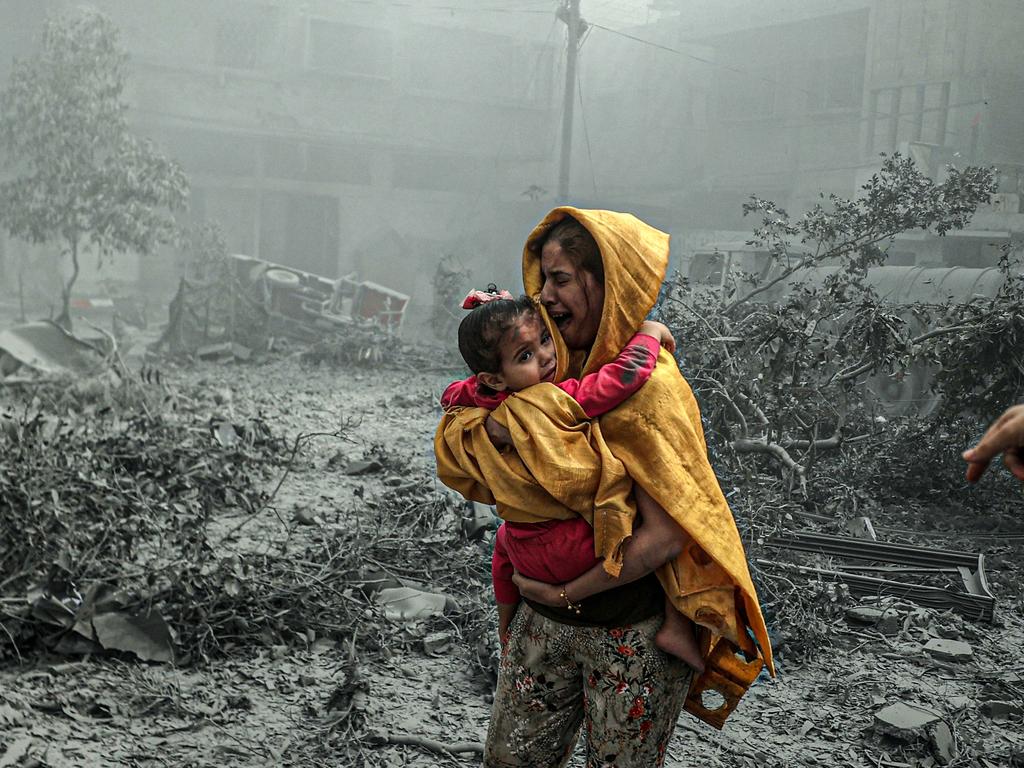 A woman holding a girl reacts after Israeli air strikes hit Ridwan neighbourhood of Gaza City. Picture: Getty