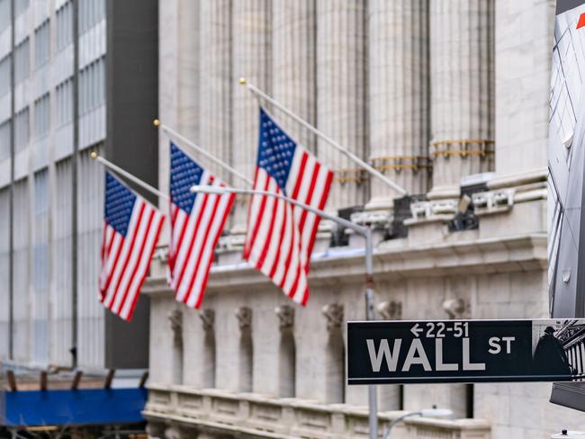 Wall street sign with New York Stock Exchange background New York City, New York, USA.