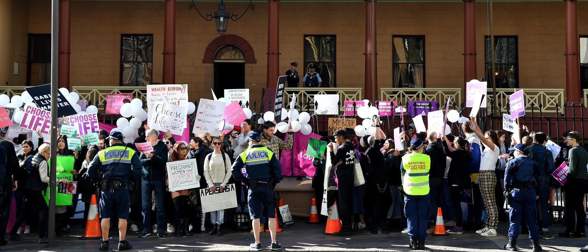 Anti-abortion (left) and pro-choice advocates seen during a rally outside the New South Wales Parliament house in Sydney, Tuesday, August 6, 2019. (AAP Image/Joel Carrett)