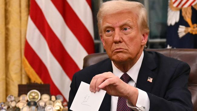 US President Donald Trump holds up outgoing President Joe Biden's letter. Picture: AFP