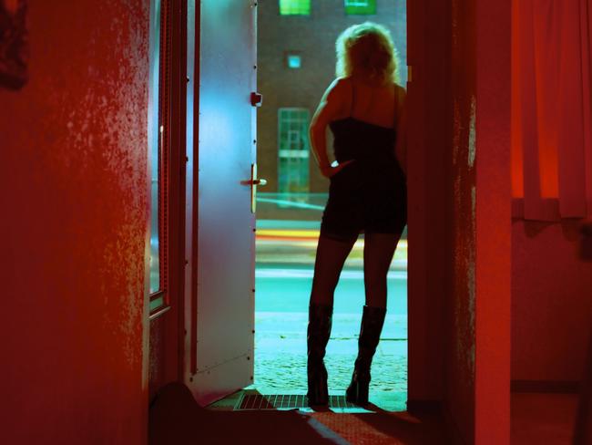 Prostitute Standing in Nightclub Doorway Looking Out