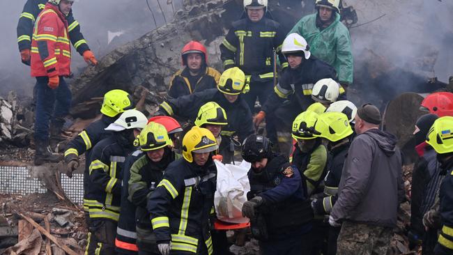 Firefighters carry the body of a civilian following a missile strike in Poltava.