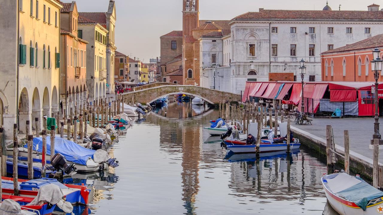 Canal Vena bordered by historic buildings in the old town of Chioggia, a coastal town situated on a small island at the southern entrance to the Lagoon of Venice.