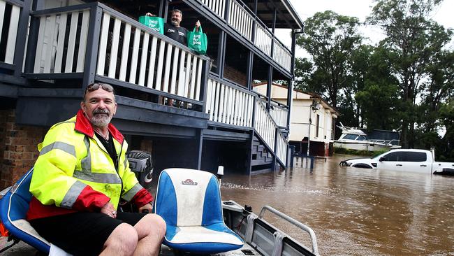 Moorebank local resident Tony Lippis delivering food to his brother-in-law Steve Arnold from his tinny. Picture: Jane Dempster.