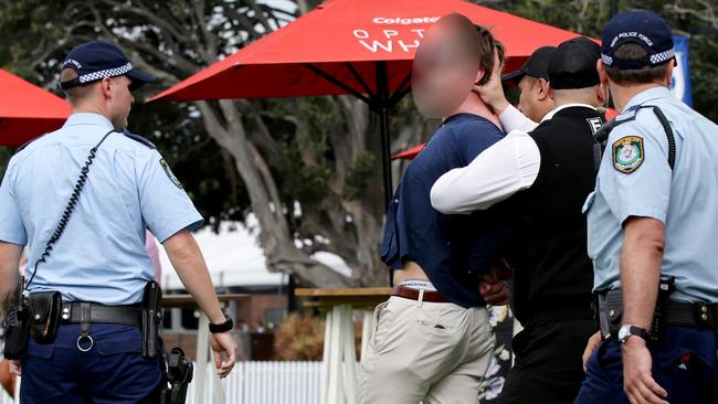 A racegoer in handcuffs at Royal Randwick yesterday. Picture: Jonathan Ng