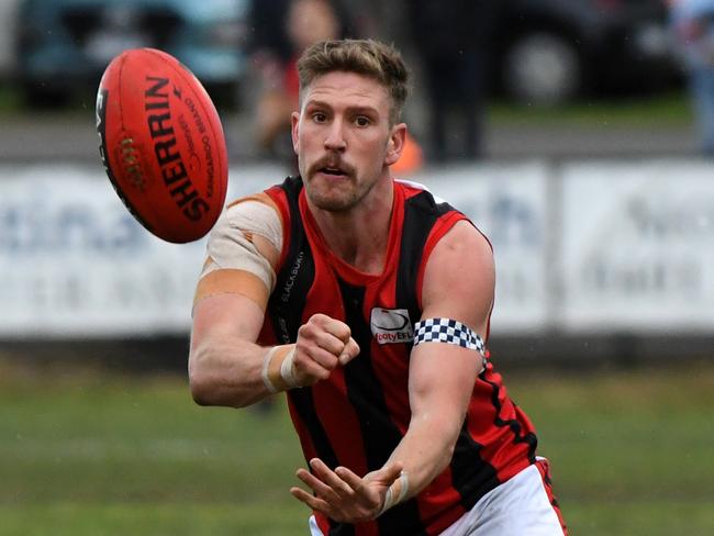 Michael Dunn feeds out a handball. Picture: James Ross/AAP