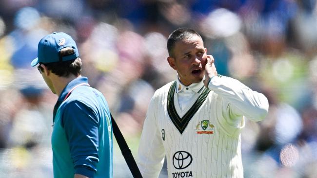 Usman Khawaja retires walking off the Adelaide Oval after being struck by a bouncer in the dying moments. Picture: Izhar Khan / AFP.