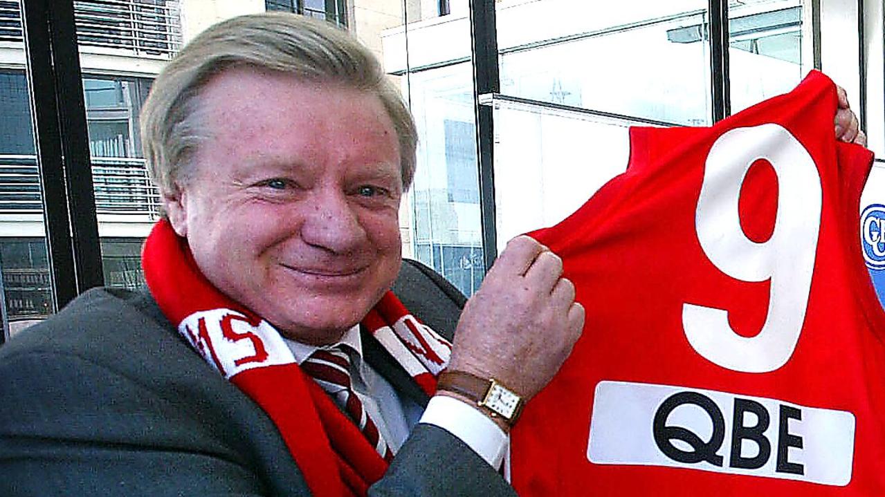 SPORT AFL – 18.8.03 – Swans Chairman Richard Colless with a jumper for the President of Collingwood Eddie McGuire during a promotion for this Saturday's big game between the two sides. pic. Phil Hillyard.